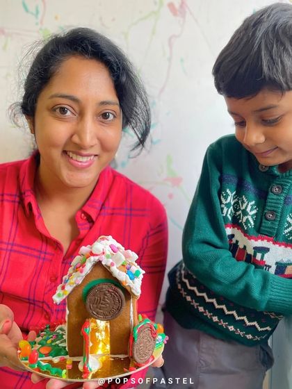 A mother and son admire their finished gingerbread house, a wonderful creation from our festive workshop.
