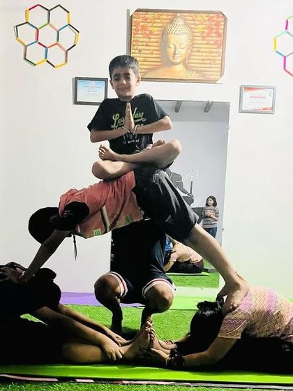 Combining multiple poses into one acro yoga structure. We have seated forward fold, downward facing dog, and a lotus pose on top.