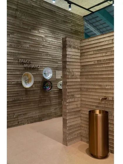Inside the stall, the textured cardboard walls provide a neutral canvas for displaying bathroom fixtures and washbasins.