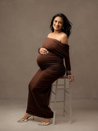A confident and happy seated pose. This shows how we can use simple props like a stool to create elegant and varied portraits.