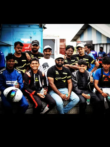 The team poses for a photo in the pit lane.