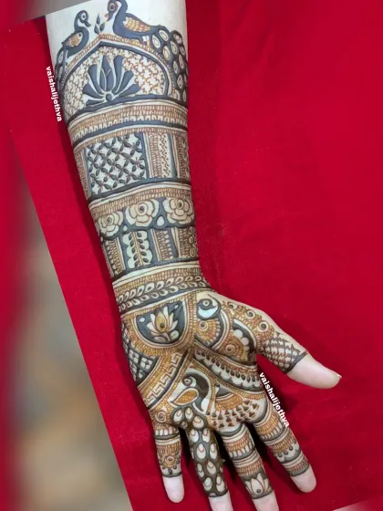 A full-arm bridal design showcasing a variety of patterns, including lotuses, peacocks, and complex geometric fills.