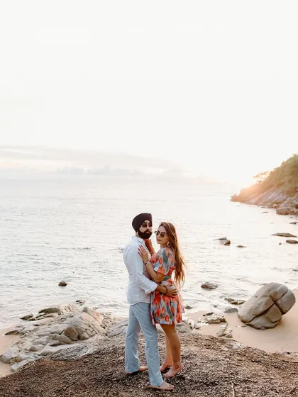 A classic beach portrait at sunset, with the couple embracing by the water.