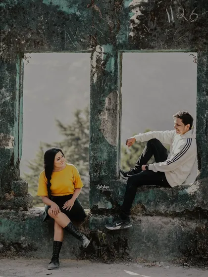 A relaxed, conversational pose in the window of a rustic structure in Mussoorie. This casual setup allows for natural and comfortable interactions.