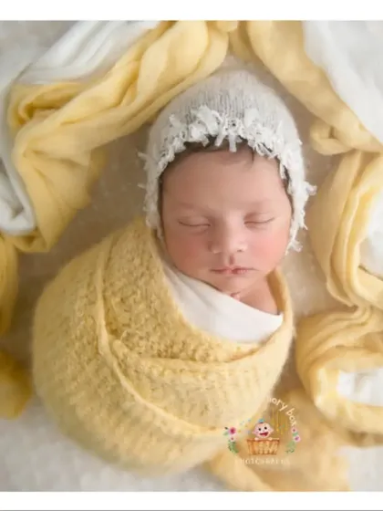 This little sunflower is wrapped in a beautiful yellow knit. The simple white background makes the color pop and keeps the focus on the baby.