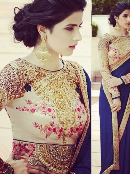 A high-neck, full-sleeve blouse with heavy floral and gold embroidery. This regal design is perfect for creating a statement look for a wedding or formal event.