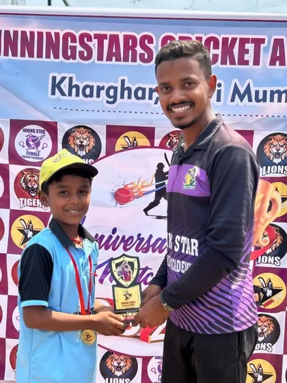 A proud moment for a young cricketer as he receives a trophy for his efforts during our academy's anniversary celebration.