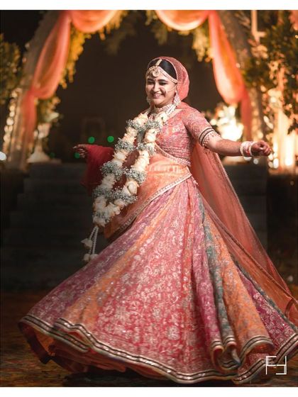 A full-length shot of Nidhi, capturing the beautiful twirl of her lehenga. This dynamic portrait shows off the entire bridal outfit and captures a moment of joyful movement.