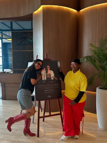 Posing with my event poster and a friendly staff member on my last day in Oman. Building good relationships at venues is a professional skill I emphasize.