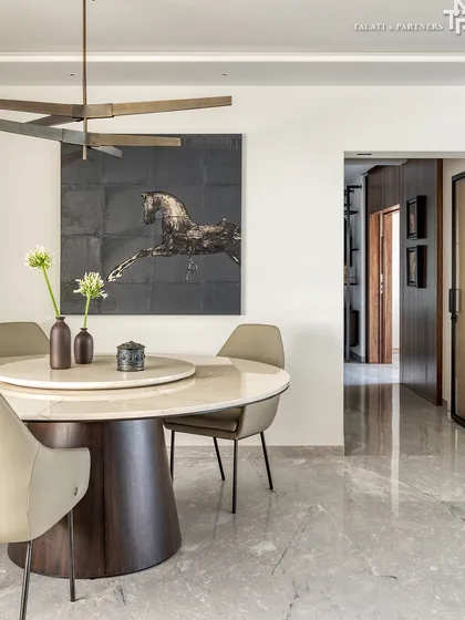 A minimalist dining area within a larger living space, reflecting an Indian interpretation of the ethos. Here, craftsmanship, emotion, and heritage come together to create a space that’s as personal as it is poetic, with a bold painting of a horse adding a dynamic element.