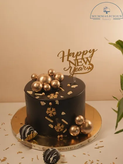 Ring in the New Year with glamour. This black and gold chocolate truffle cake, adorned with golden spheres, is a sophisticated and decadent way to celebrate the start of a new year.
