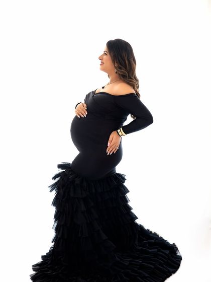 A beautiful side profile of a mumma-to-be in a glamorous gown. This pose is perfect for showcasing the baby bump in an elegant and flattering way.
