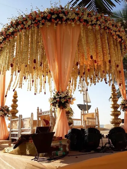 A beachside wedding calls for a mandap that complements the natural beauty. I designed this stunning Vidhi Mandap with cascading floral strings and delicate peach drapes, creating a romantic and serene setting against the ocean backdrop.