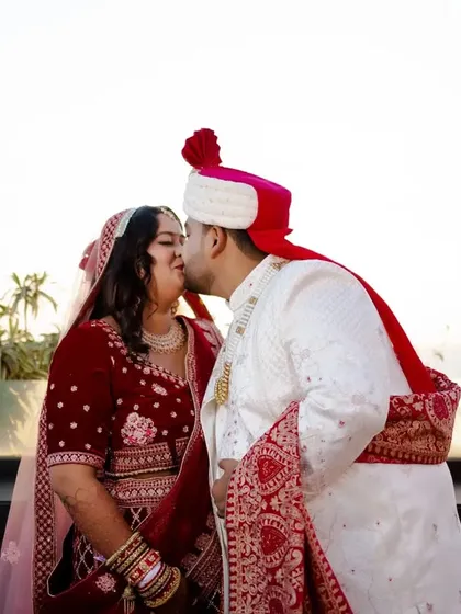 A romantic kiss on the cheek against the sky, a simple and beautiful moment of affection.