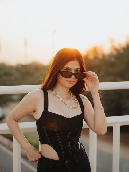 A playful portrait from the golden hour series, with the subject peering over her sunglasses. This shot has a fun, candid feel while still benefiting from the beautiful, warm backlighting.