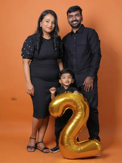 Celebrating a second birthday in style. This studio family portrait uses a bold, solid-color backdrop and a simple prop to mark a special milestone, creating a clean and classic image perfect for your wall.