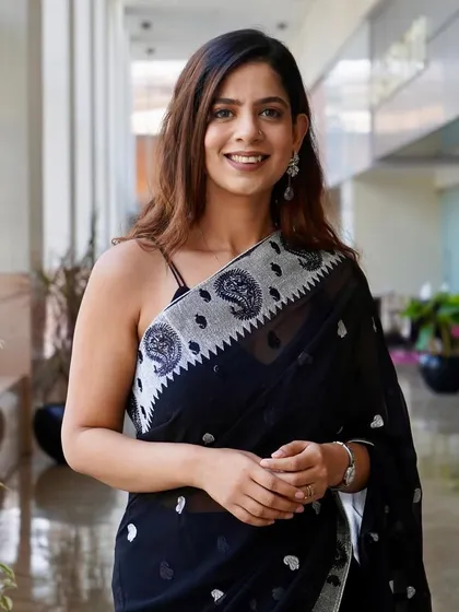 A close-up in the black saree. The intricate border adds a touch of elegance.