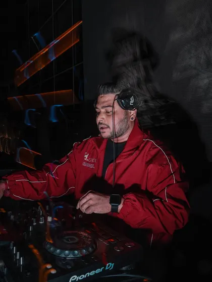 A long-exposure shot showing the movement and energy around the DJ booth.