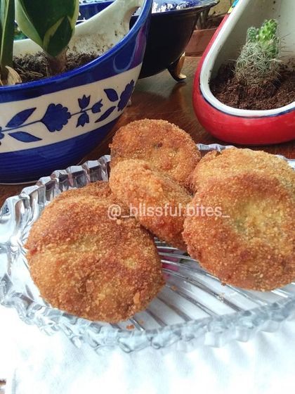 A plate of golden-brown Malai Kebabs, showcasing their crispy breadcrumb coating.