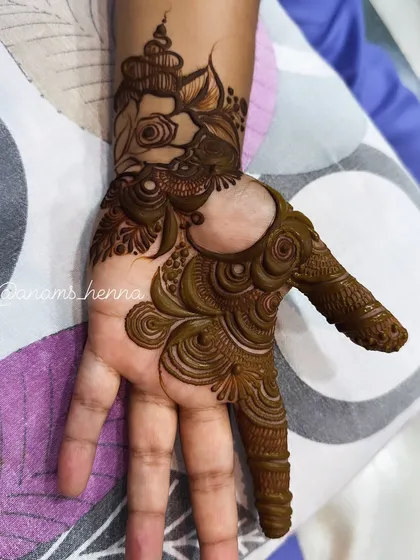 A unique design featuring an elephant-like motif on the thumb. This is a fun and creative take on traditional henna.