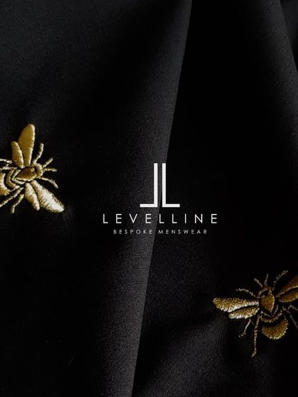 The bee embroidery on black fabric, a design element that adds a touch of modern luxury to a traditional piece.