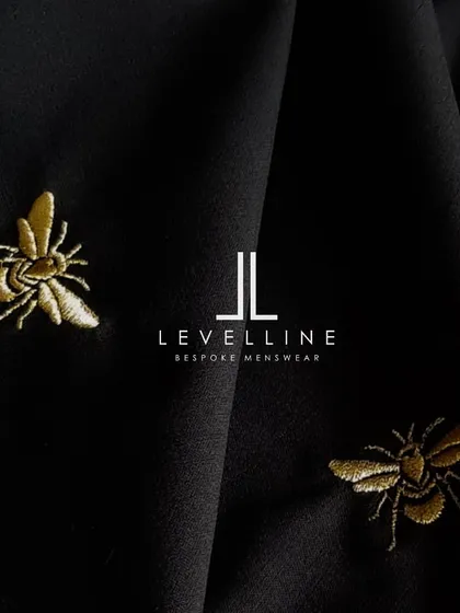 The bee embroidery on black fabric, a design element that adds a touch of modern luxury to a traditional piece.