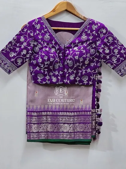 A purple blouse with heavy silver zardozi work. The floral pattern covers the entire blouse, making it a statement piece for any saree.