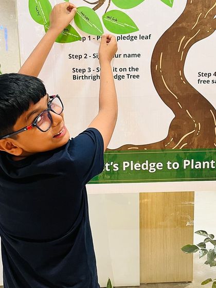 Even our youngest Green Warriors are passionate about making a difference. This young boy is proudly adding his name to our pledge tree, committing to a future with more trees.