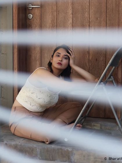 Using the lines of window blinds to create a striped light and shadow effect for an artistic and moody portrait.