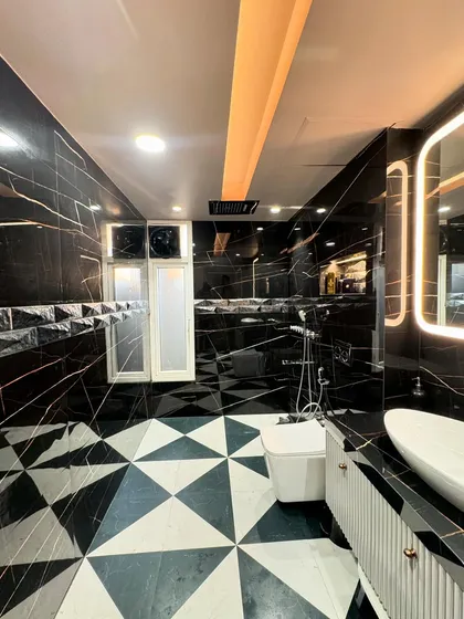 A glimpse into a luxury bathroom I designed, featuring black marble with gold veining and geometric floor tiles. I focus on high-end materials and flawless execution to create spaces like this, handling all the plumbing, tiling, and electrical work myself.