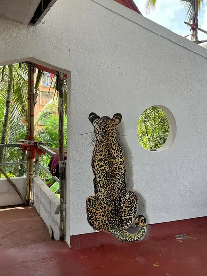 The leopard mural, seen from a distance, looks like it's peering out from the wall.