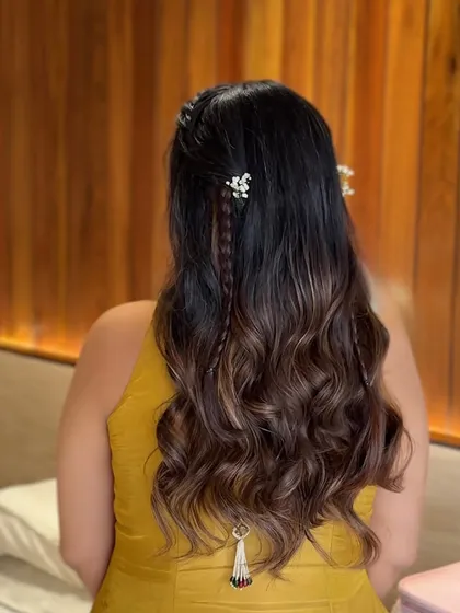 A detailed back view of the half-updo, showing the combination of braids, waves, and a traditional hair accessory.