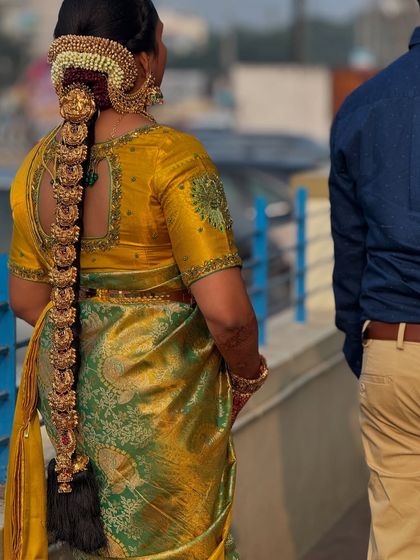 A shot from the back, highlighting Prithivi's intricate bridal braid adorned with heavy, traditional gold jewellery. This is a key element of the classic South Indian bridal look.