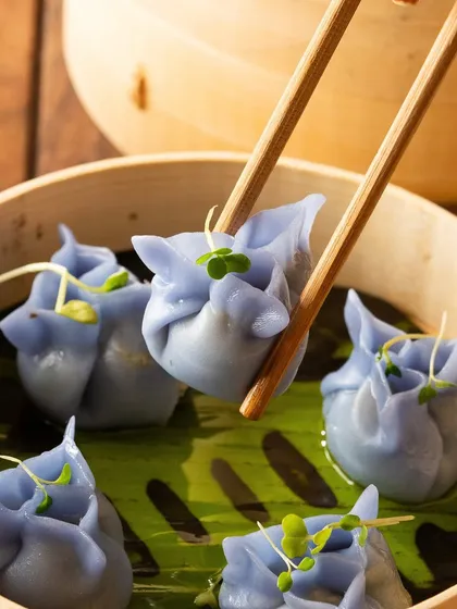 Another angle of the beautiful blue pea flower dumplings, showing the delicate folds and shape.