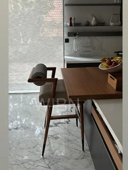 A side profile of our custom barstool, highlighting the expert joinery and the elegant tapering of the solid wood legs.