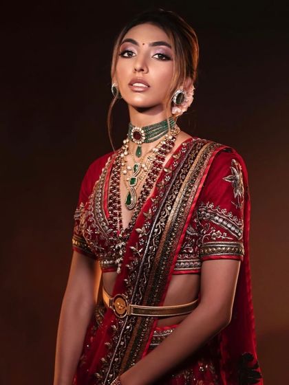 A close-up of a classic red bridal look. The makeup is timeless and elegant, with a focus on a flawless base and defined eyes.