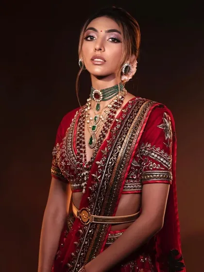 A close-up of a classic red bridal look. The makeup is timeless and elegant, with a focus on a flawless base and defined eyes.