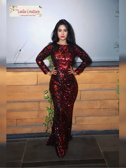 A full-length view of the red and black sequin gown. The long sleeves and simple neckline balance the bold texture of the sequins, creating a sophisticated party dress.
