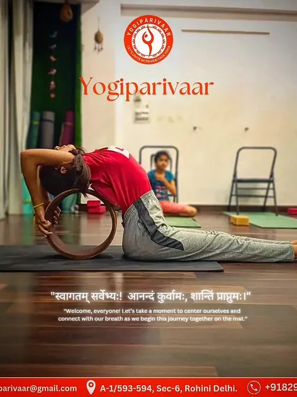 A student uses a yoga wheel to support a deep backbend, opening the chest and shoulders safely.