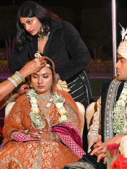 As a stylist, I'm often hands-on during the most important moments. Here, I'm assisting with the bride's wedding ceremony rituals, ensuring she looks and feels perfect.