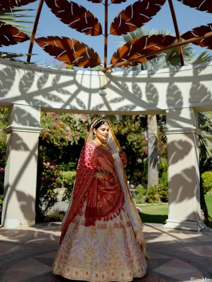 A beautiful full-length portrait of the bride under a shaded archway. The play of light and shadow adds a lovely artistic touch to this elegant shot.
