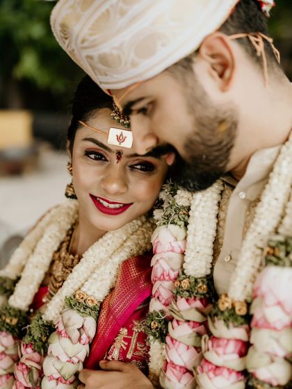 A beautiful close-up of the couple, capturing the bride's loving gaze and the intricate details of their wedding attire.