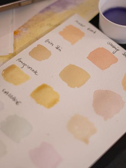 A color chart testing the different shades of handmade botanical inks. Participants create these swatches to see the range of colors derived from sources like onion skin, pomegranate, and butterfly pea flowers.