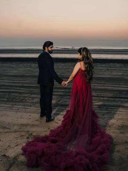 Capture the romance of twilight on the beach in this deep red flying gown. The long, flowing train adds drama and movement, creating a perfect silhouette for a sunset couple's maternity shoot.