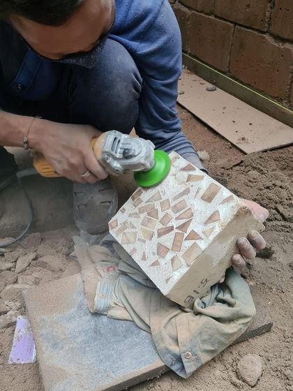 An artisan carefully works on a prototype, a crucial step in our design development. This hands-on approach allows us to refine the form, texture, and feel of a piece before final production.