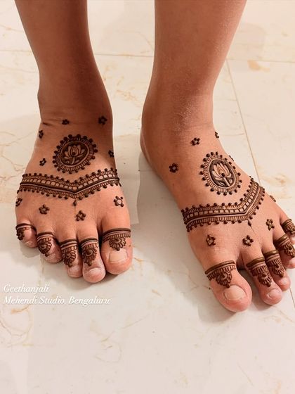 A simple and beautiful foot mehendi for a mom-to-be. The design features a lotus mandala on the top of the foot with minimal patterns on the toes.