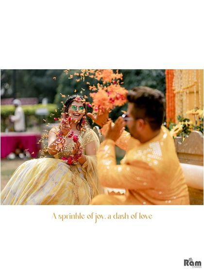 A perfect capture of "a sprinkle of joy, a dash of love." The groom showers his bride with flower petals during their Haldi ceremony, a candid moment filled with laughter and affection.