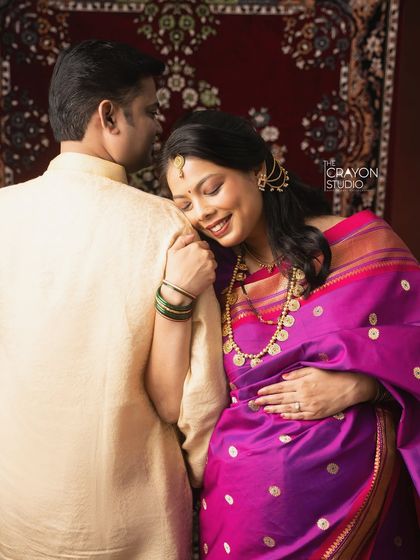 A quiet moment of connection. She rests her head on his shoulder, a simple and loving pose that speaks volumes about their partnership as they await their baby.