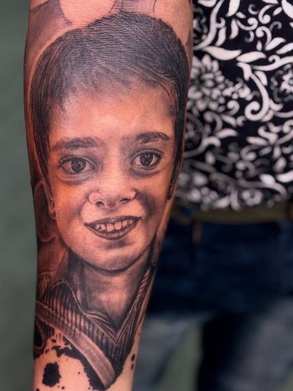 Another angle of the child portrait tattoo, showing the smooth shading and realistic details that make the piece feel alive.