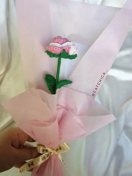 A single, elegant crochet rose with two-tone pink and white petals. Wrapped in soft pink paper, this is a timeless gift of affection that will never wilt.
